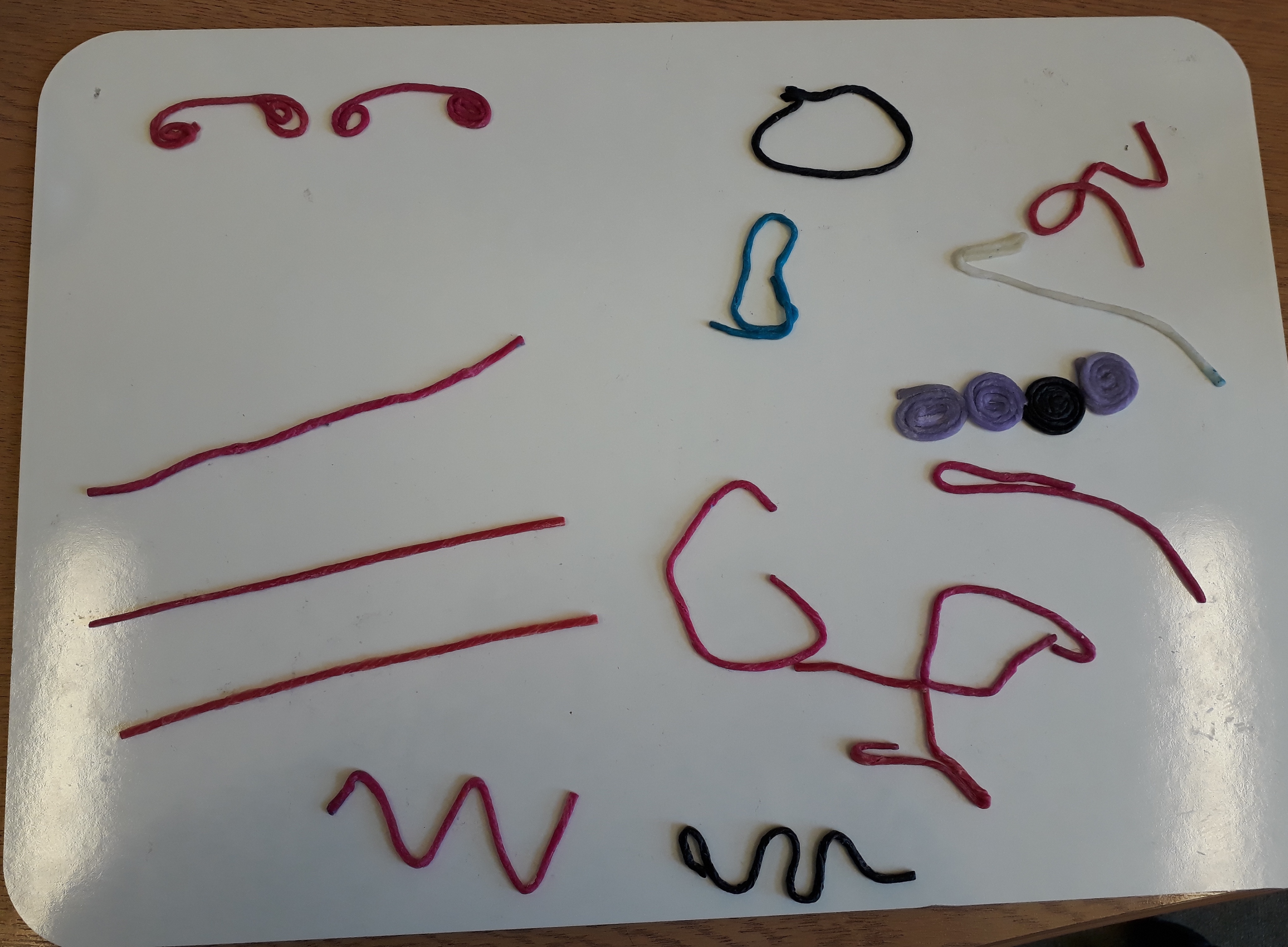 Another example of shapes made from wax sticks on a white board. 